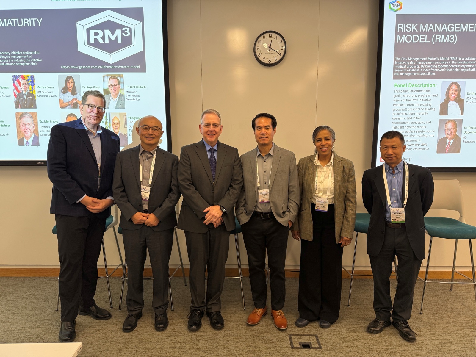 RM3 panelists standing together in front of the Risk Management Maturity Model presentation screens.